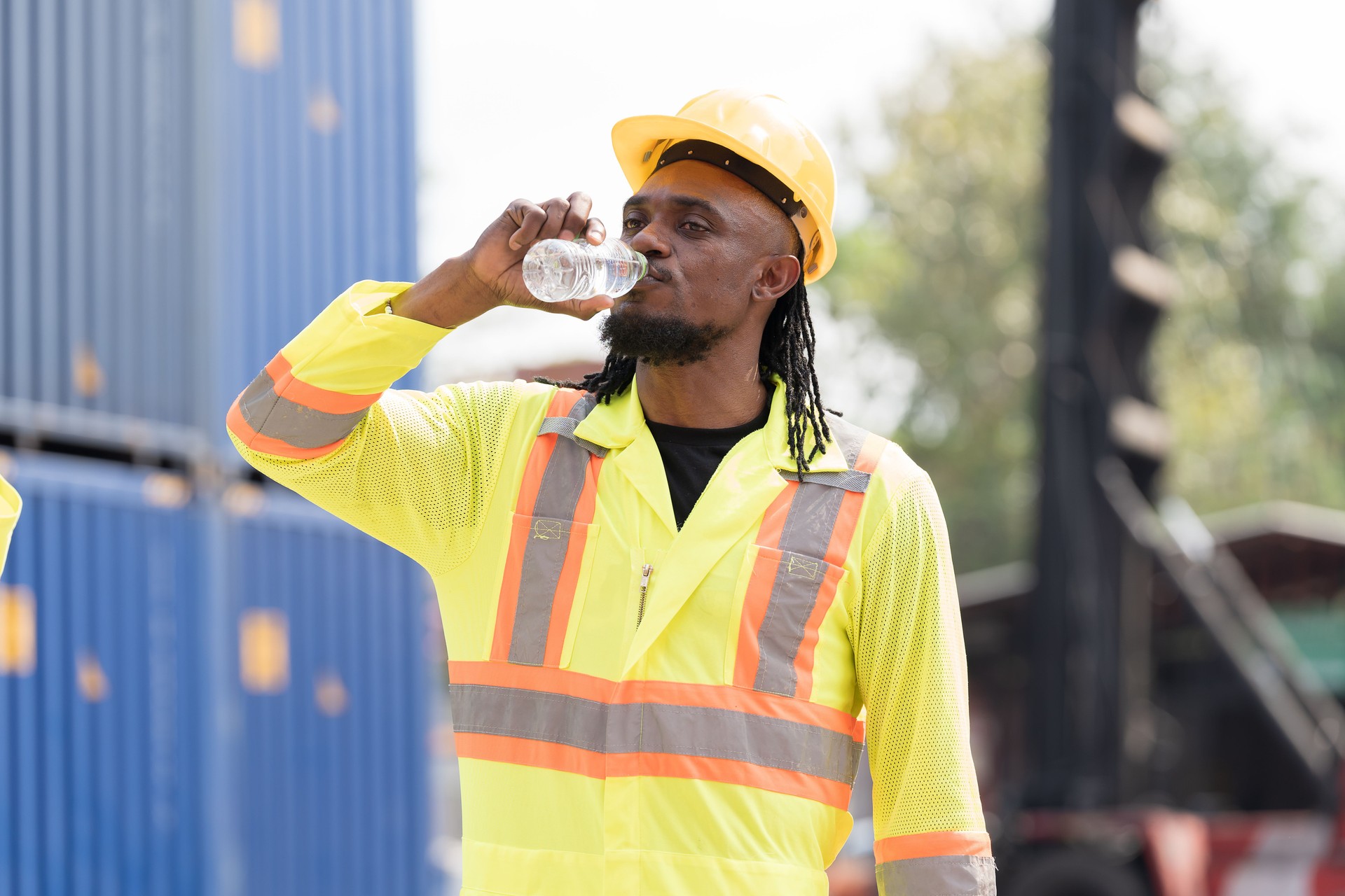 Drinking water,  worker and container cargo site. Male container yard worker break and drinking water at container cargo yard